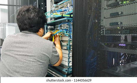 man working in network server room with UTP cables connected 
