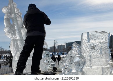 Man Working On Carving An Ice Sculpture Of A Narwhal At Meridian Place In Barrie At Winterfest 2022 Called Hello Winter Barrie, Ontario, Canada - February 5, 2022