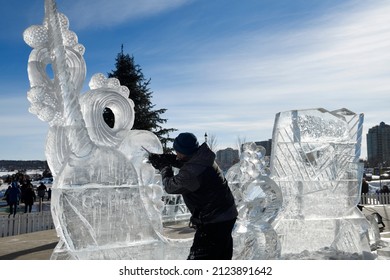 Man Working On Carving An Ice Sculpture Of A Narwhale At Meridian Place In Barrie On Kempenfelt Bay At Winterfest 2022 Called Hello Winter Barrie, Ontario, Canada - February 5, 2022