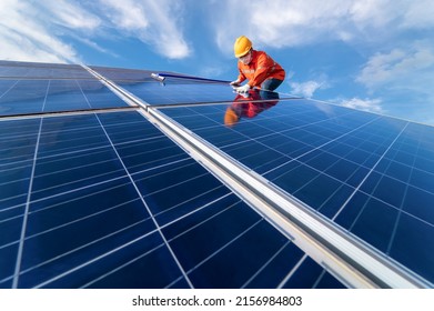 Man Is Working On Cleaning Solar Panels. Repair, Maintenance, Reuse, And Periodical Maintenance Of Solar Panels, Green Power Clean Energy Earth Conservation, And Environment Concept
