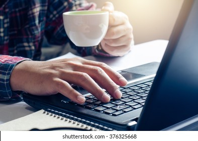 Man Working On Computer And A Cup Of Coffee