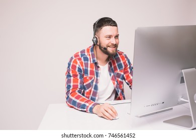 Man working on computer with headset in office