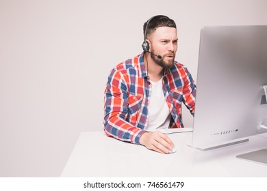 Man working on computer with headset in office
