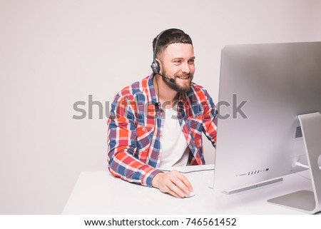 Man working on computer with headset in office