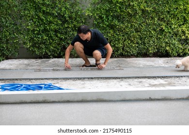man working on explsed aggregate finish the front of the house