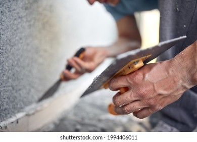 Man working on a house facade. - Shutterstock ID 1994406011