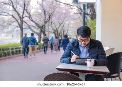 A Man Working On IPad Under Cherry Blossom Full Bloom 

Location Seokchon Lake , Seoul , South Korea
Date  16-04-2019