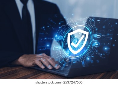 Man working on a laptop with advanced cyber security shield, ensuring the protection of sensitive data and securing the digital environment against potential threats.	