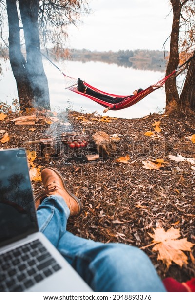 man working on laptop at camping site autumn fall\
season. freelance concept