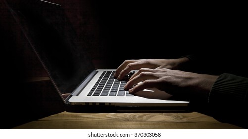 Man Working On Laptop In Dark Room