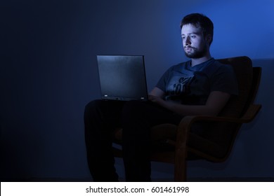 Man Working On A Laptop In A Dark Room At Night