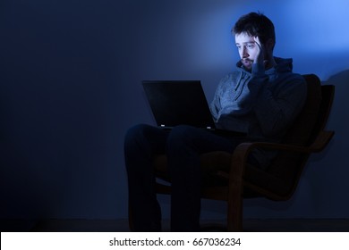 Man Working On A Laptop In A Dark Room At Night