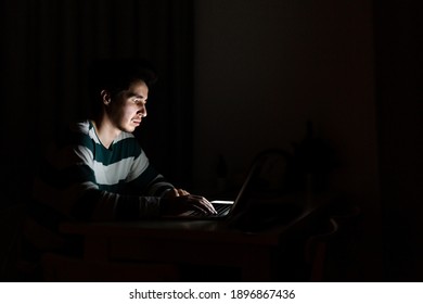 A Man Working On A Laptop At Home At Night.