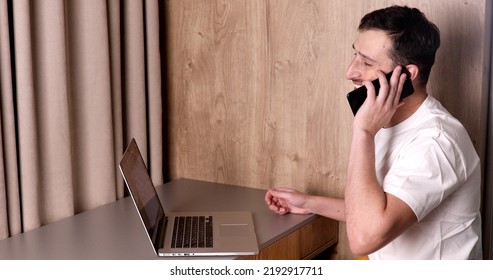 A Man Working On A Laptop At Home.