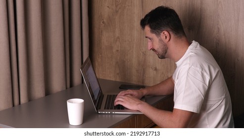 A Man Working On A Laptop At Home.