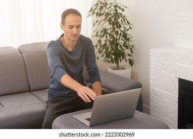 A Man Working On A Laptop At Home