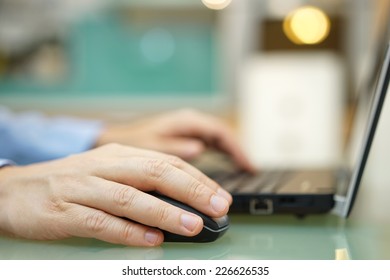 Man Is Working On Laptop At Home. Shallow Depth Of Field , Focus On Mouse