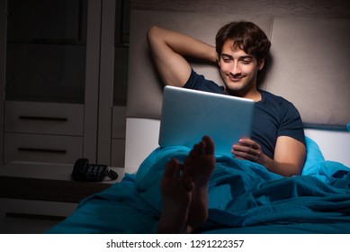 Man Working On Laptop At Night In Bed