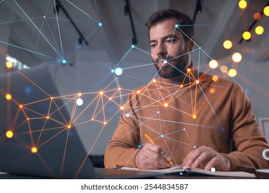 A man is working on a laptop while writing in a notepad, with a digital network overlay. Blurred background. Concept of technology and data - Powered by Shutterstock