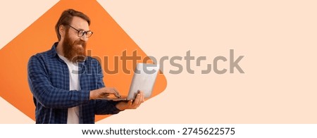 Man Working on Laptop While Standing in Front of an Orange Background in a Simple Setting