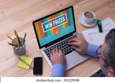 Man working on laptop with WIN PRIZES on a screen - Shutterstock ID 359229098