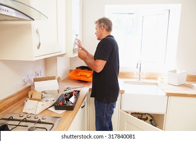 Man Working On A New Kitchen Installation
