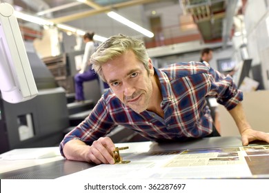 Hombre trabajando en una máquina de impresión en una fábrica de impresión