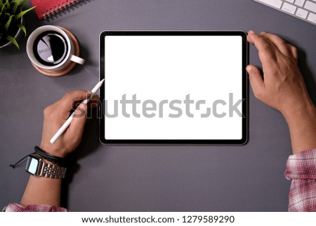 Man working on tablet computer with blank screen at office desk