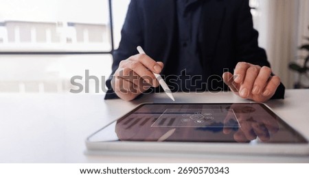 Man working on a tablet computer in a modern office. Make an account analysis report. real estate investment information financial and tax system concepts
