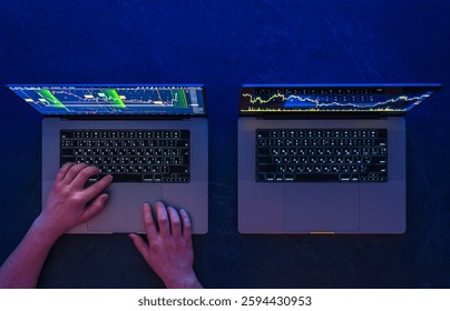 Man working on two laptops. Stock market. Trading. Investments. Top view.