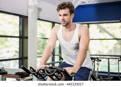 Man Working Out At Spinning Class In Gym