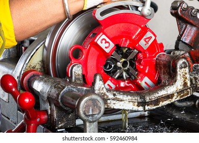 Man working pipe threading machine was made thread with the threaded hose connection in site construction.