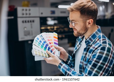 Man working in printing house with paper and paints - Shutterstock ID 1961107642