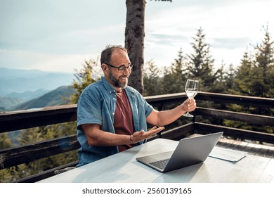 Man working remotely on laptop from mountain cabin - Powered by Shutterstock