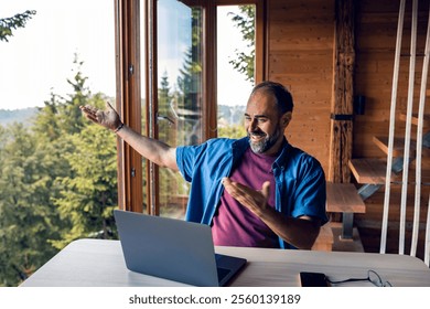 Man working remotely on laptop from mountain cabin - Powered by Shutterstock