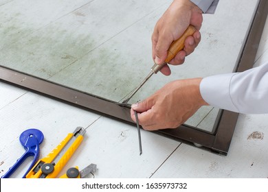 A Man Working For Repairing Window Screen