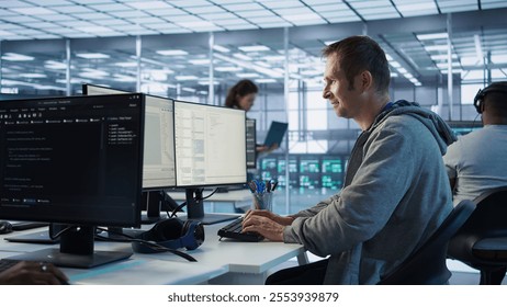 Man working in server hub capable of processing vast amounts of data. IT programmer at PC desk typing on keyboard, updating servers controlling network resources, camera B
