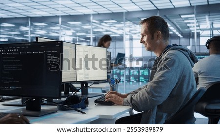 Man working in server hub capable of processing vast amounts of data. IT programmer at PC desk typing on keyboard, updating servers controlling network resources, camera B