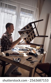 Man working in a small home workshop for furniture repairing and restoration.