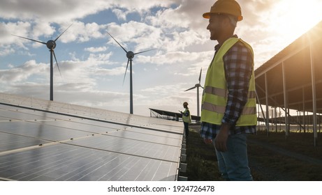 Man Working For Solar Panels And Wind Turbines - Renewable Energy Concept - Focus On Male Worker Face