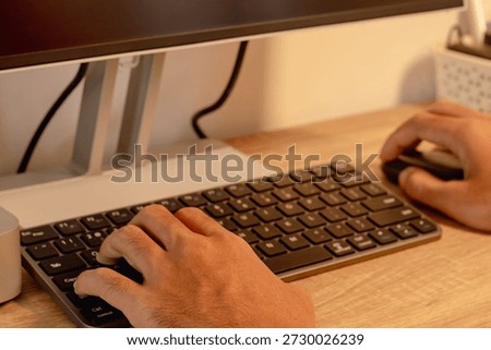 A man working using a computer. Close up shot of male hands on computer keyboard and mouse.
