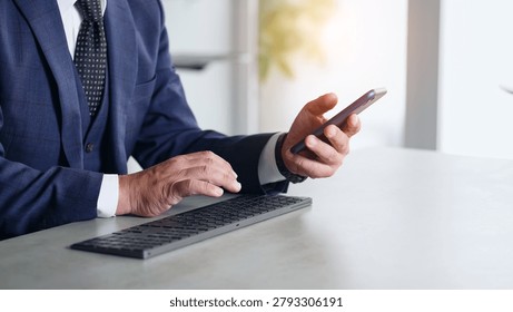 A man working using his smartphone and PC.