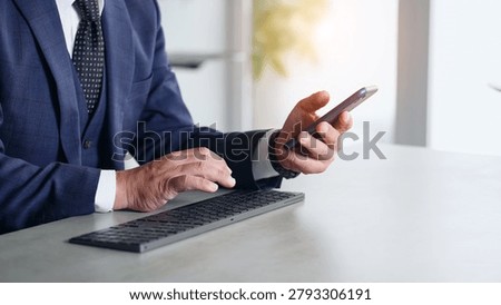 A man working using his smartphone and PC.