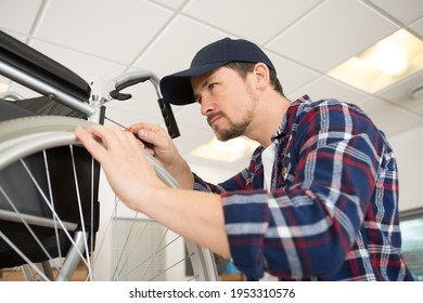 man working in wheelchair repair shop - Powered by Shutterstock