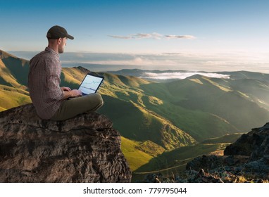 man working wireless outdoors with laptop