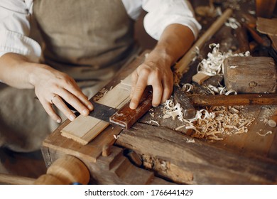 Mann, der mit einem Holz arbeitet. Zimmermann auf weißem Hemd