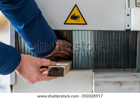 Man working with wood machine. Failure to comply with safety