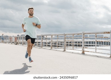 Man in workout clothes running along a sunny waterfront promenade.

 - Powered by Shutterstock