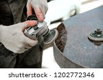 A man works polishing a marble stone with an angle grinder. iznotovlenie monuments of natural stone