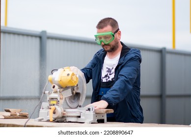 The man works with trimming saw. He is wearing a welder's protective mask and protective gloves. A rare working profession. - Shutterstock ID 2208890647